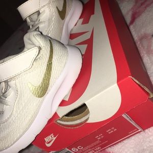 White and gold children's Nikes'.